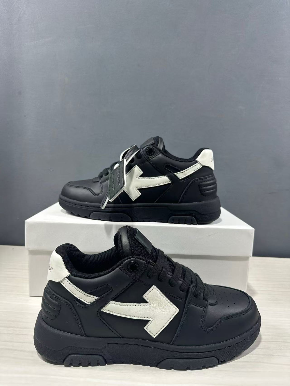 Pair of black and white sneakers shown from side and three-quarter angles, highlighting the padded collar, lace-up front, and white side detail.