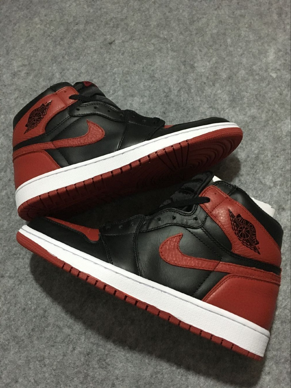 Pair of black, red, and white high-top sneakers displayed from opposing side angles.