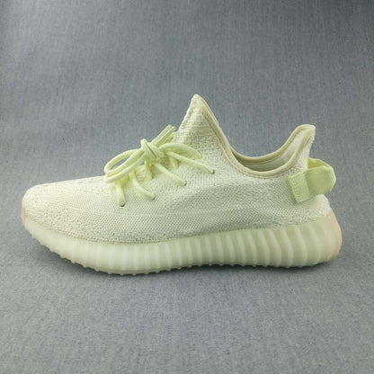Side profile of the pale butter-yellow sneaker with a textured upper and ribbed sole.