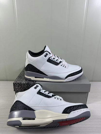 Angled close-up showing the white and grey sneakers, patterned overlays, and red outsole detail.