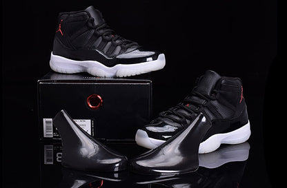 Black and white high-top sneakers displayed above and beside a black shoebox, with glossy black accessories in front.