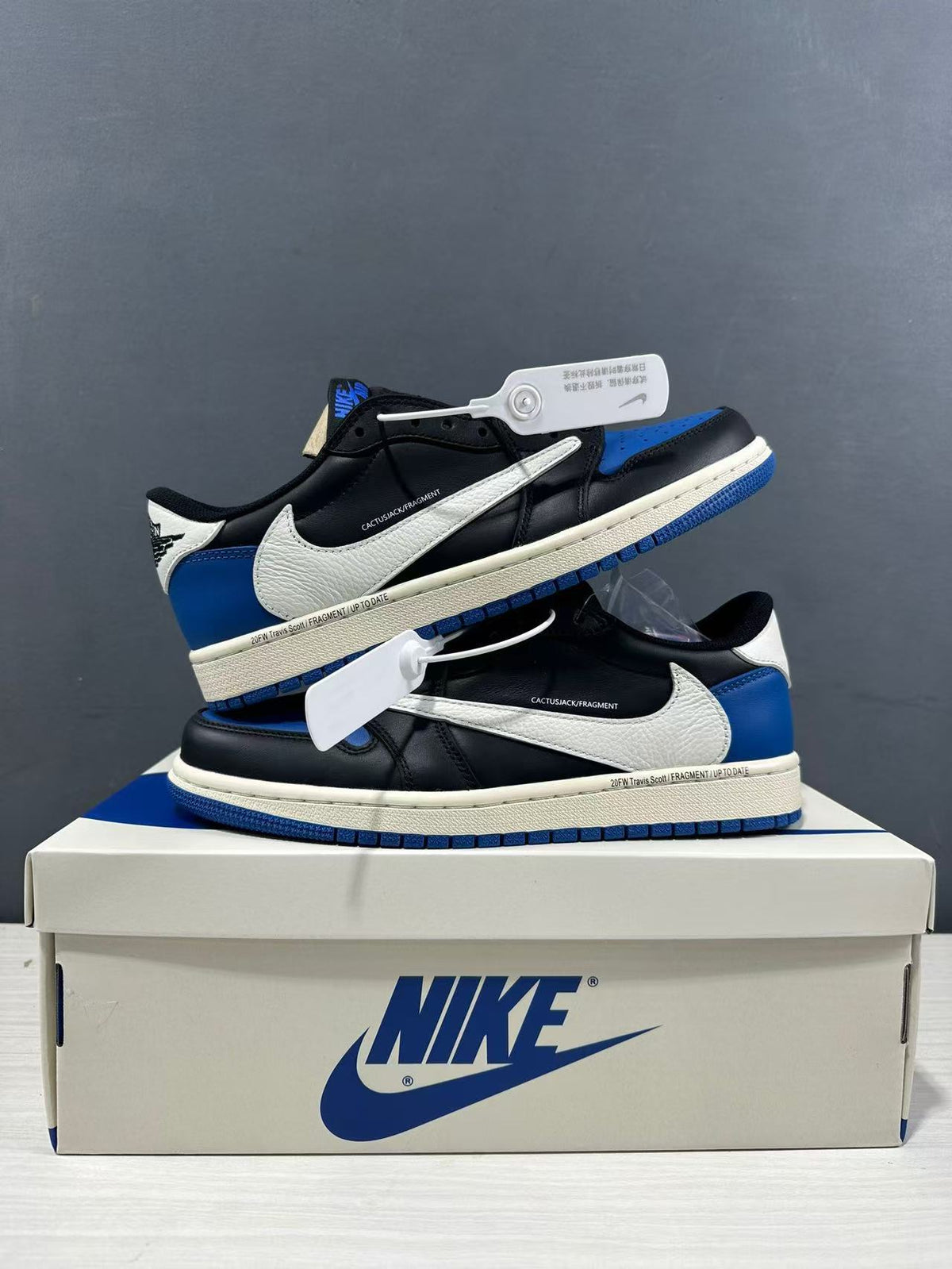 Two sneakers arranged on a shoebox to show both side profiles and blue outsole edges.