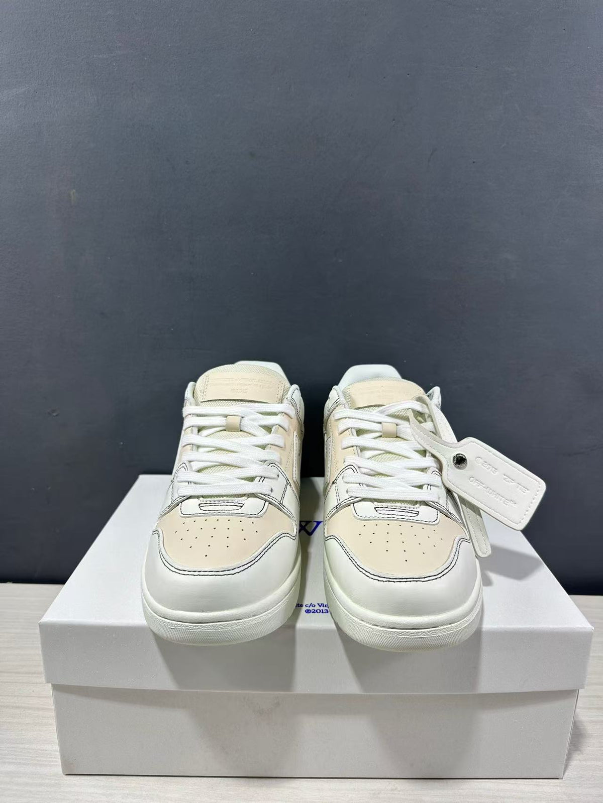 Front view of the pair showing perforated toe boxes, white laces and a hanging tag.