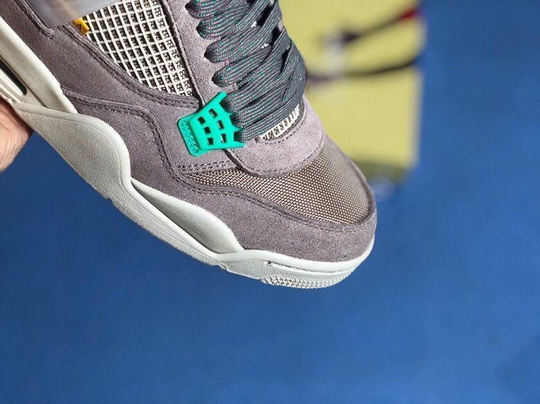Close-up of the toe box and lacing area with dark laces, grey overlays, and a teal lace support.