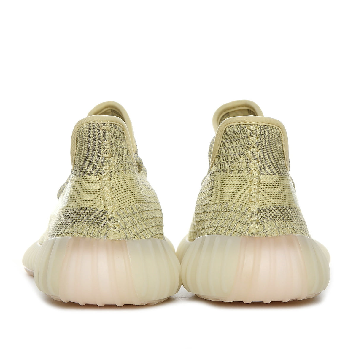 Rear view of olive green Yeezy 350 V2 sneakers showing the patterned upper and translucent ribbed soles.