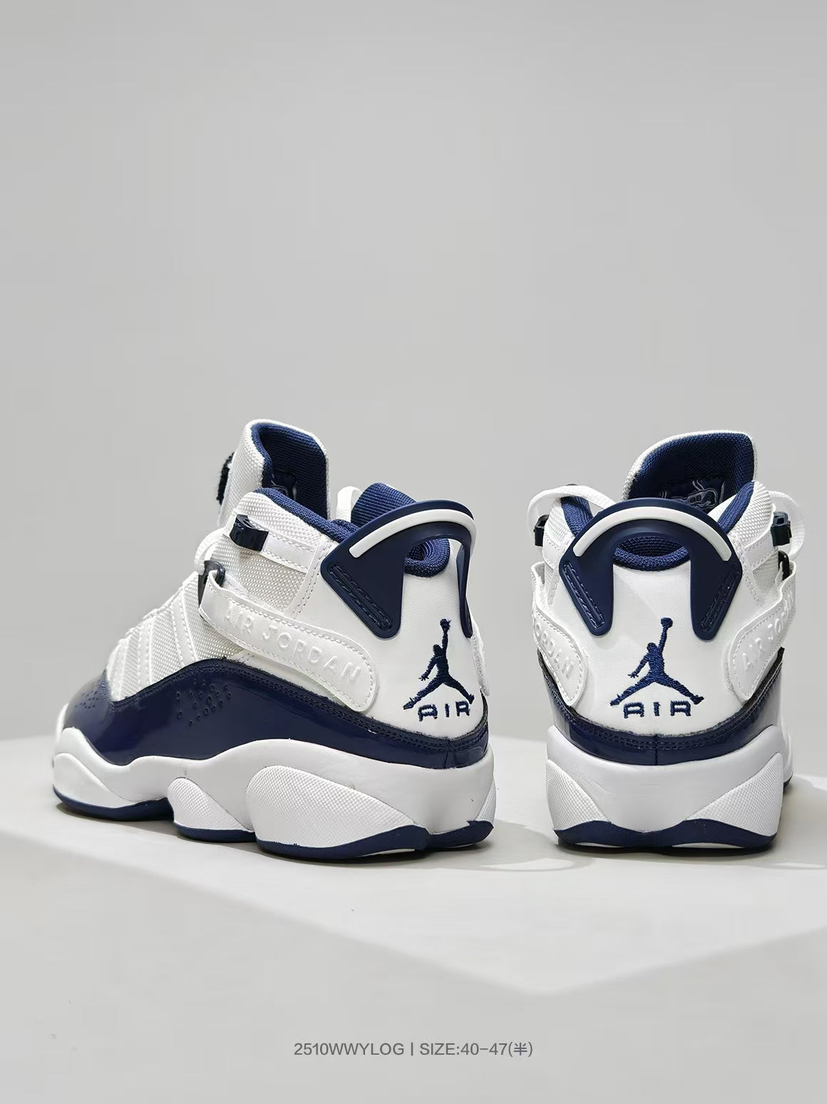 Rear view of the white and navy sneakers showing the heel branding and pull tabs.