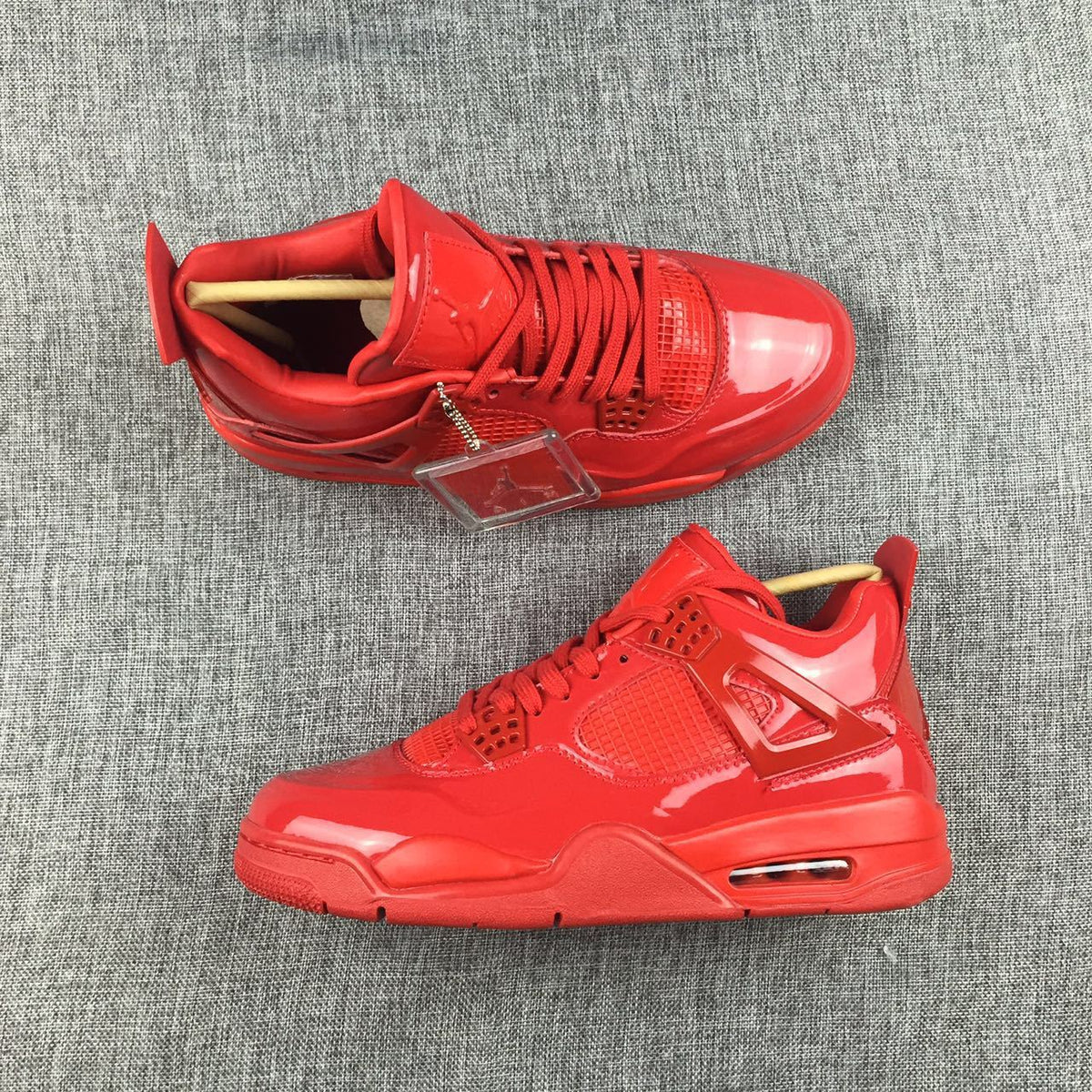Top and side view of a pair of red high-top sneakers with matching laces and glossy panels.