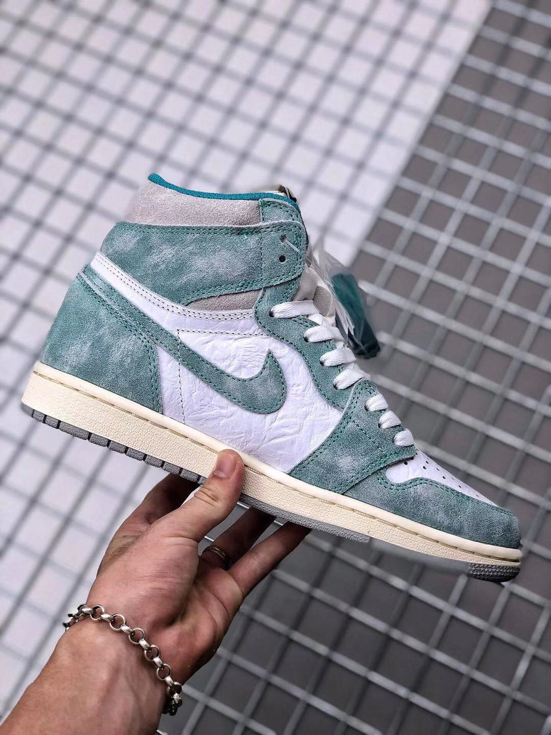 Side profile of the high-top sneaker with teal-green overlays, white panels, white laces, and a cream-colored midsole.