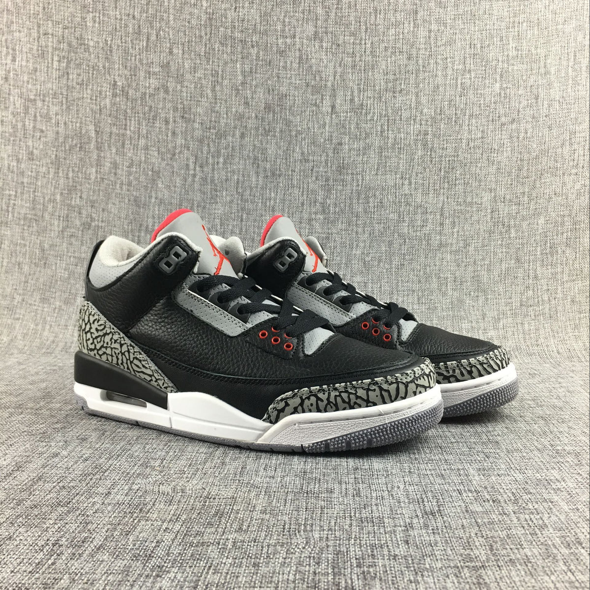 Front three-quarter view of the pair of black and grey sneakers