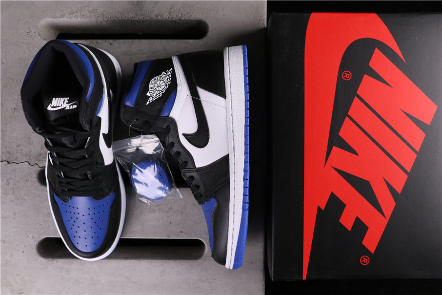 Black, white and blue high-top sneakers displayed beside a shoebox and spare blue laces.