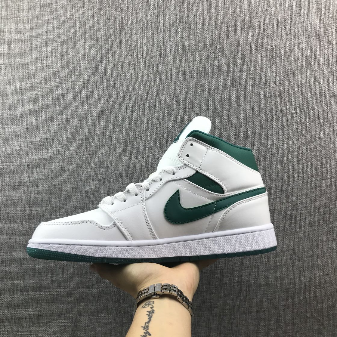 Lateral side view of the white sneaker with green Swoosh and outsole.