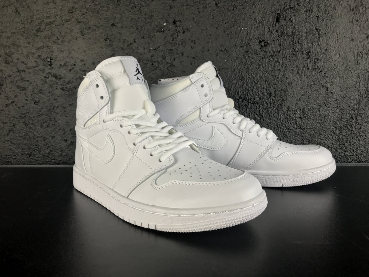 Front three-quarter view of a white pair of high-top sneakers with padded tongues, laces and perforated toe boxes.