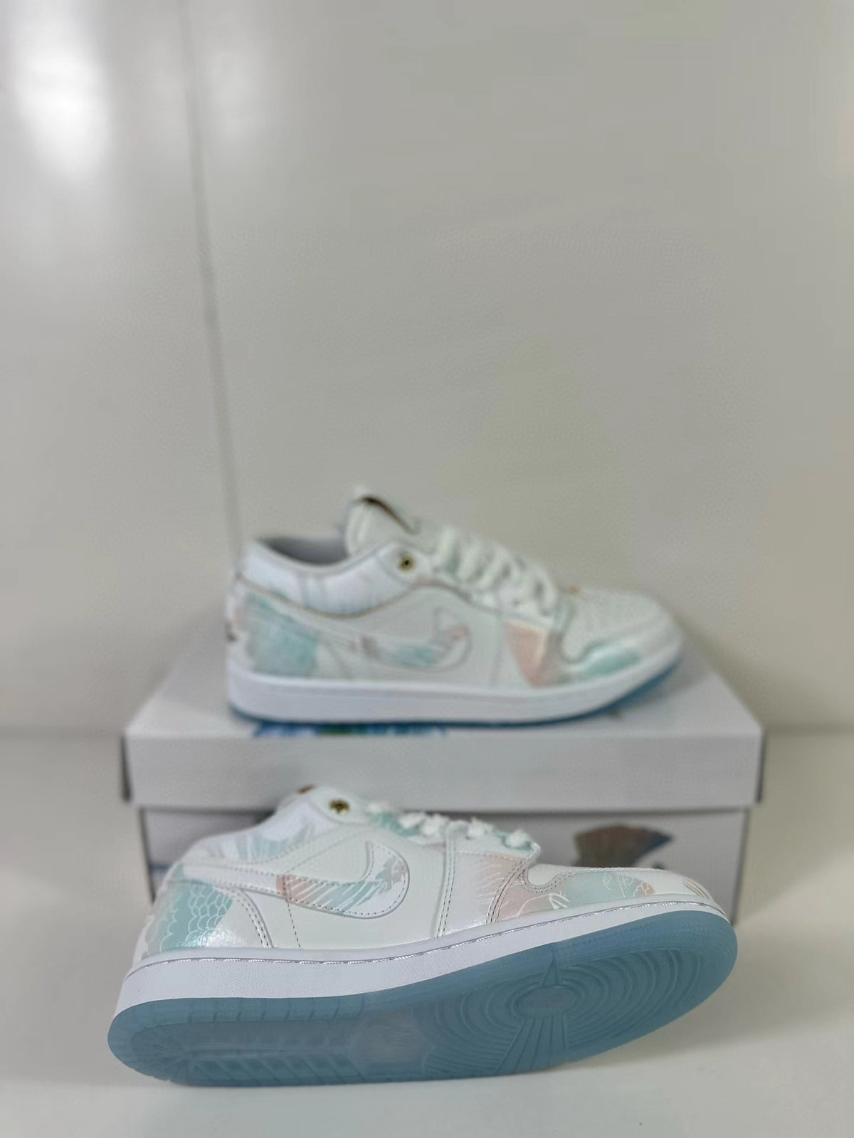 Angled view of the pair highlighting the patterned side panels and blue outsoles.