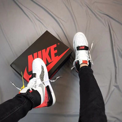 Overhead view of the sneakers worn with a black and red color-blocked upper beside the shoebox.