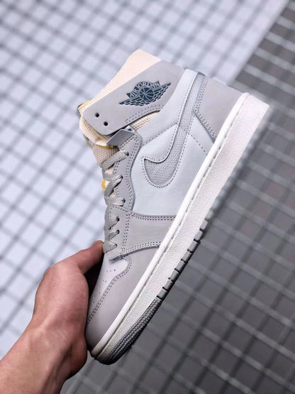 Side view of the gray high-top sneaker highlighting the Swoosh panel, winged basketball branding, and white midsole.