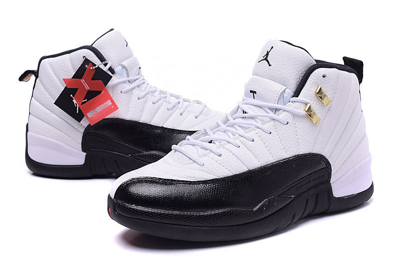 Three-quarter side view of the white and black pair with gold-tone lace hardware and attached hangtags.