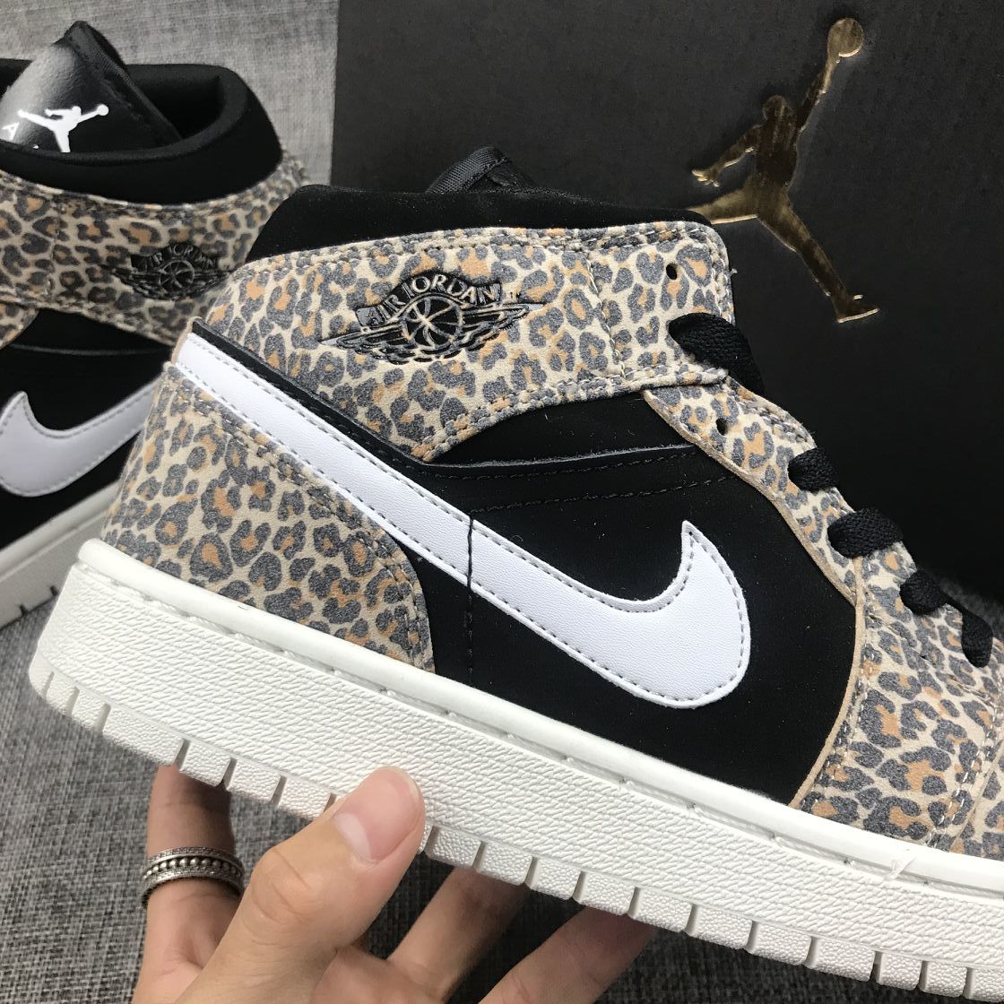 Close side view highlighting the leopard-print overlay, black quarter panel, white Swoosh, and Jordan Wings detail.