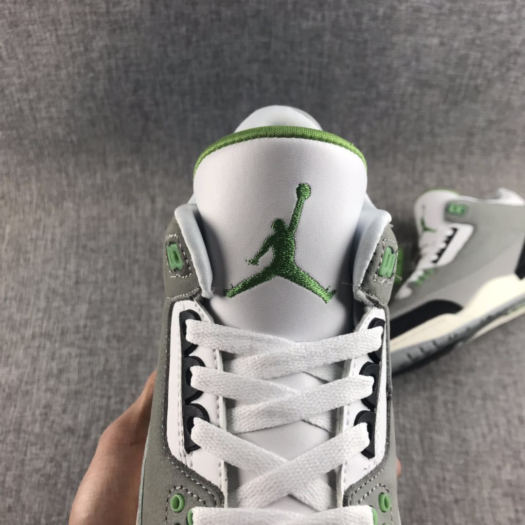 Top-down close-up of the white tongue with green Jumpman branding and white laces.