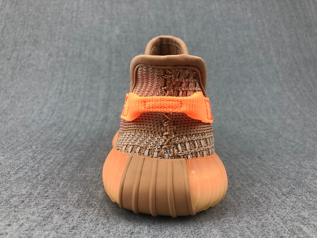Rear view showing the orange heel detail, woven upper, and rounded ribbed outsole.