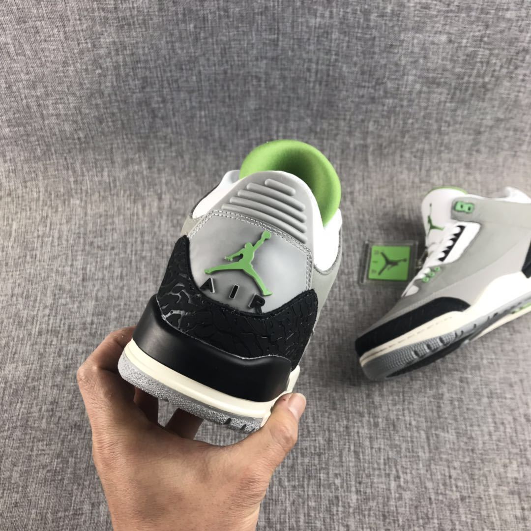 Rear view of a gray sneaker showing the green Jumpman detail, black heel overlay, and light outsole.