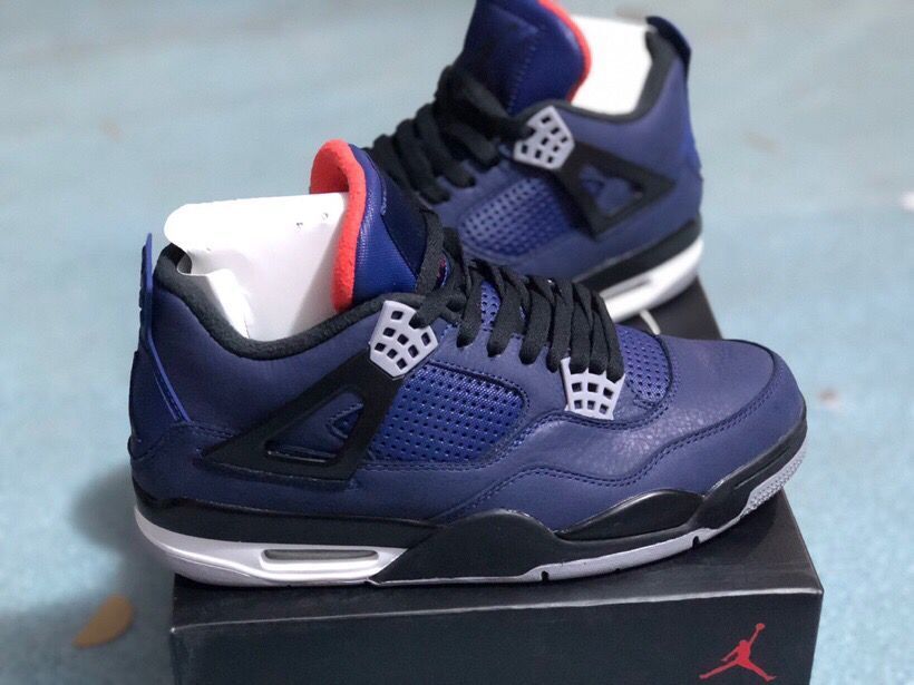 Side view of dark blue Jordan 4 sneakers with perforated panels and a visible midsole air unit