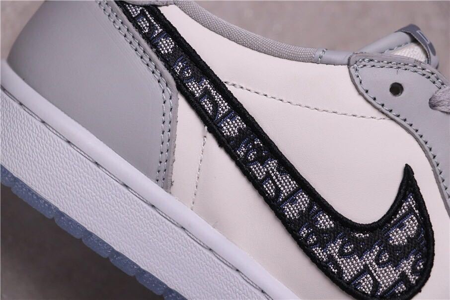 Close-up of the black patterned side Swoosh against the light grey upper.