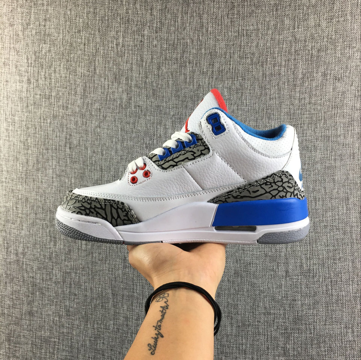 Pair of Air Jordan 3 Retro sneakers viewed from the side, highlighting the white upper and patterned overlays.