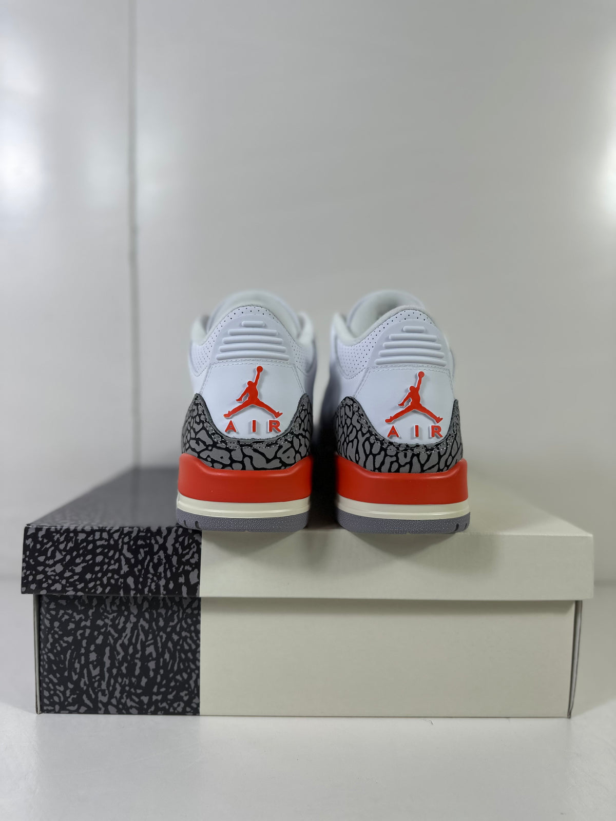 Rear view showing red Jordan logos, grey elephant-print heel overlays, and red midsole accents.