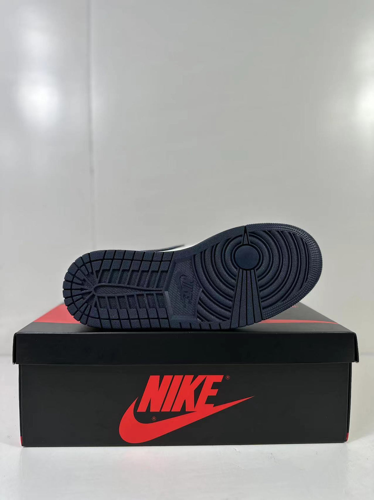 Black outsole of the low-top sneaker resting on a Jordan shoebox.