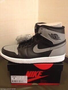 Side view of the black and grey high-top sneaker showing the contrasting Swoosh and white midsole.