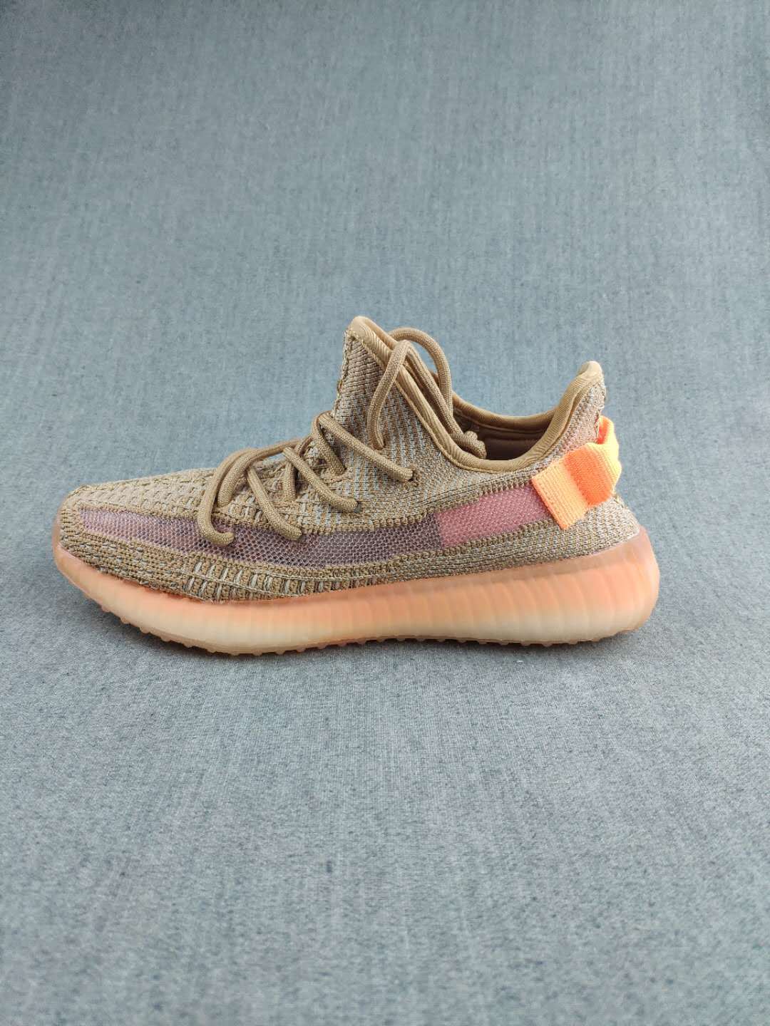 Single side-profile sneaker displaying the tan and mauve colorway with orange heel accents.