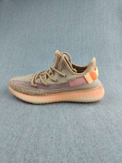 Single side-profile sneaker displaying the tan and mauve colorway with orange heel accents.
