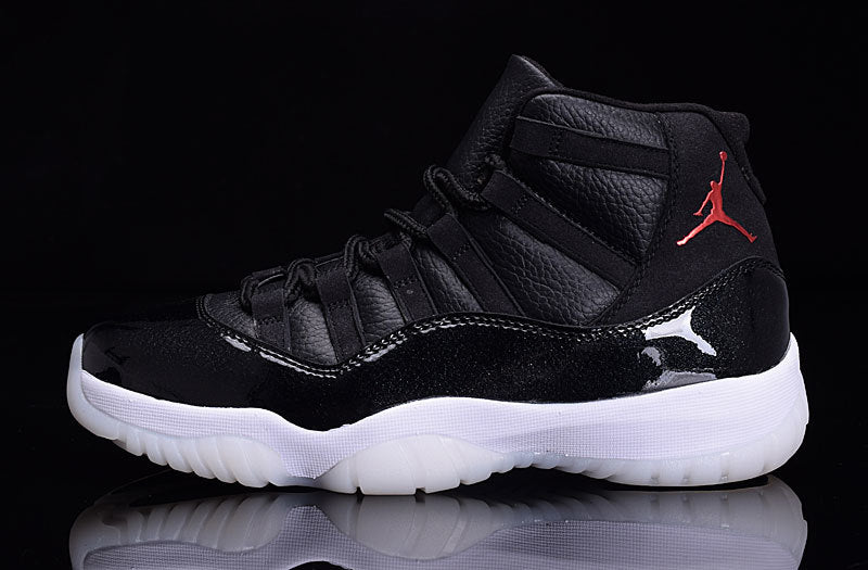 Side profile of a black high-top sneaker with red heel branding, glossy black paneling, and a white translucent outsole.
