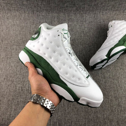Handheld three-quarter view of the white and green high-top sneaker showing its side construction.