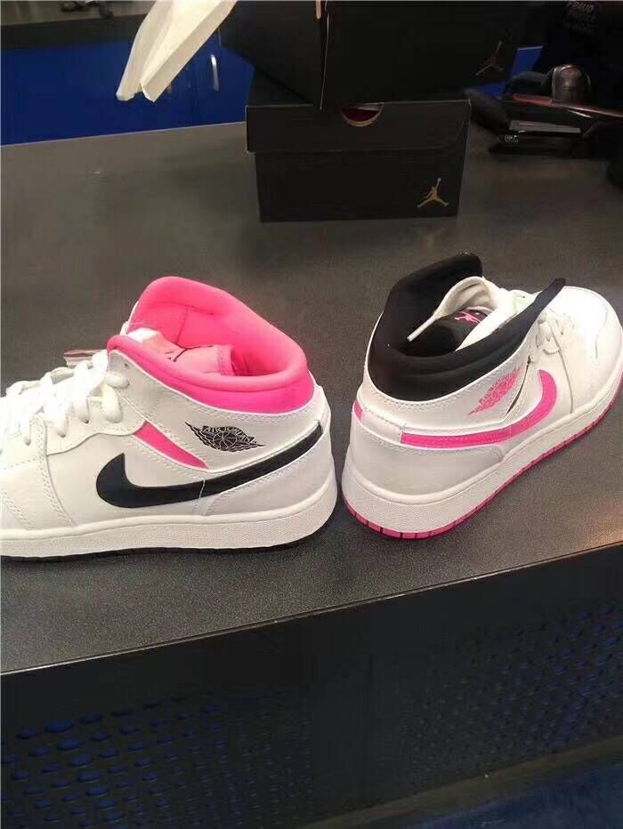 Rear views of white mid-top sneakers with pink and black details