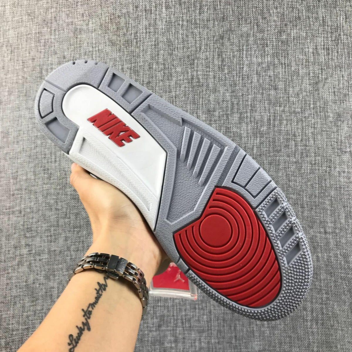 Underside view showing the grey outsole pattern, red circular traction area, and red branding detail.
