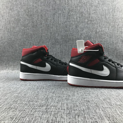 Three-quarter view of the pair showing the black and red upper, white Swooshes, and white midsoles.