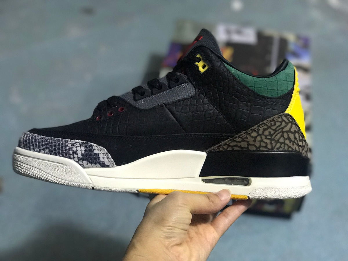 Side profile highlighting the textured black upper, patterned toe and heel panels, and green and yellow accents.