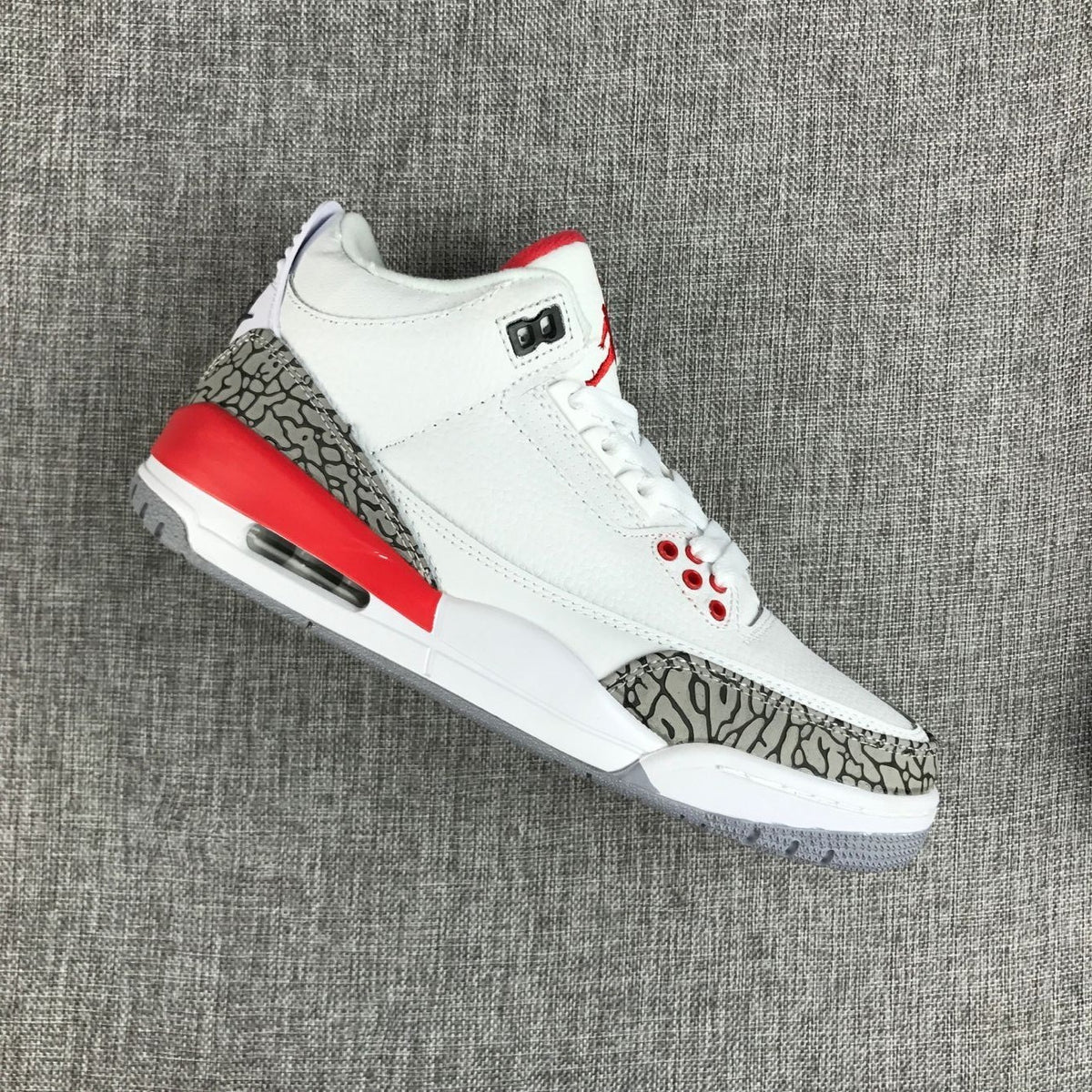 Angled side view showing the grey elephant-print overlays and red accents