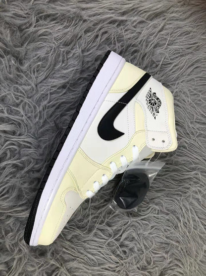 Side view of one cream and white mid-top sneaker showing the black side design, ankle strap detail, and black outsole edge.