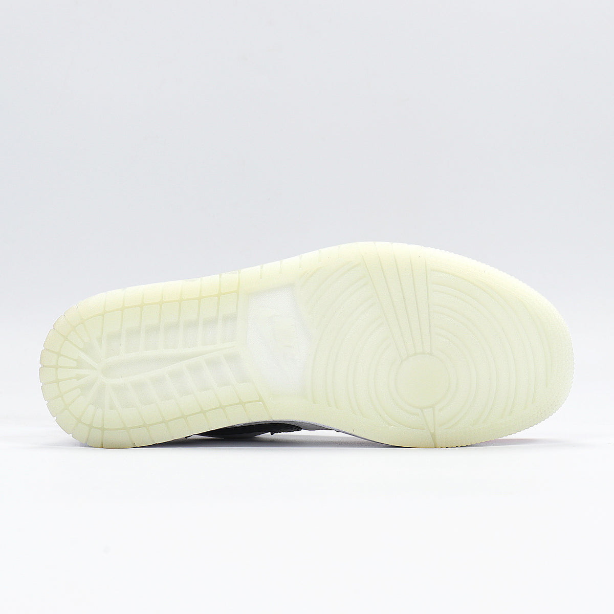 Bottom view showing the translucent light outsole with circular and segmented traction patterns.