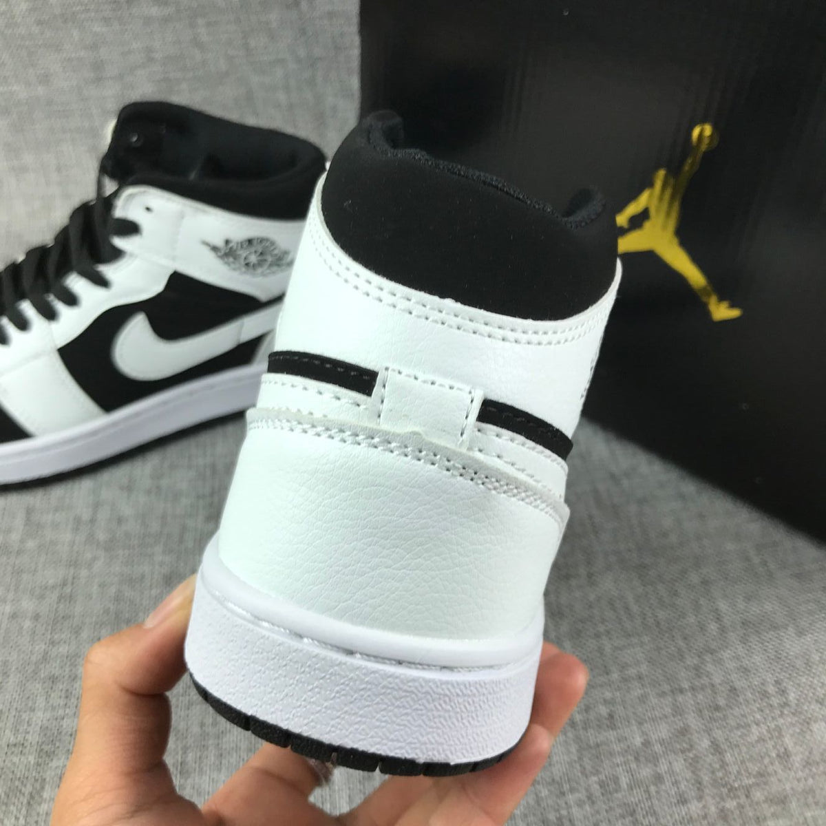 Close-up of the rear heel, black padded collar, white panels, and white midsole.