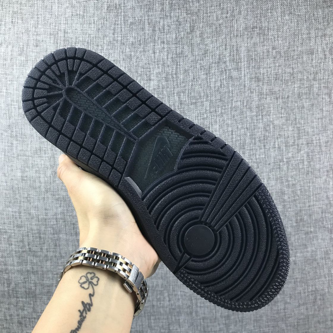 View of the black rubber outsole showing segmented tread and circular traction grooves.