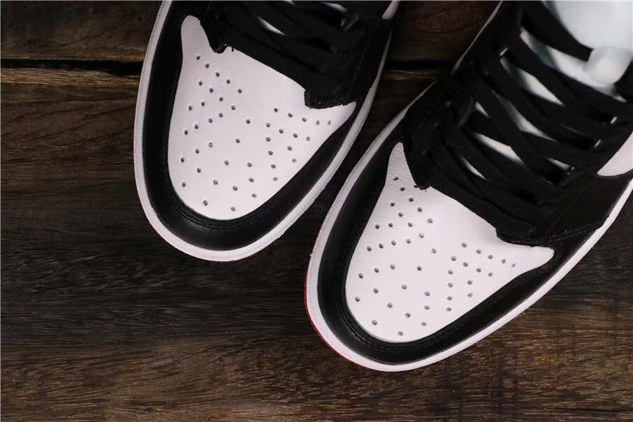 Top view of the perforated white toe boxes framed by black overlays.
