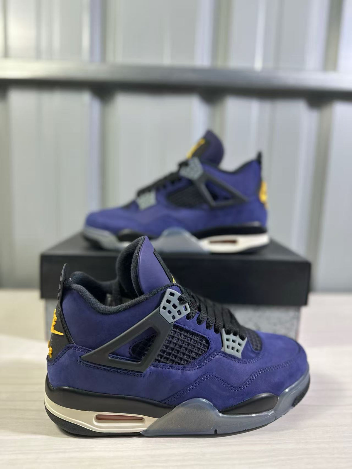 Close side view of a purple Jordan Air Jordan 4 sneaker showing the mesh panel, lace support, and heel cushioning window.