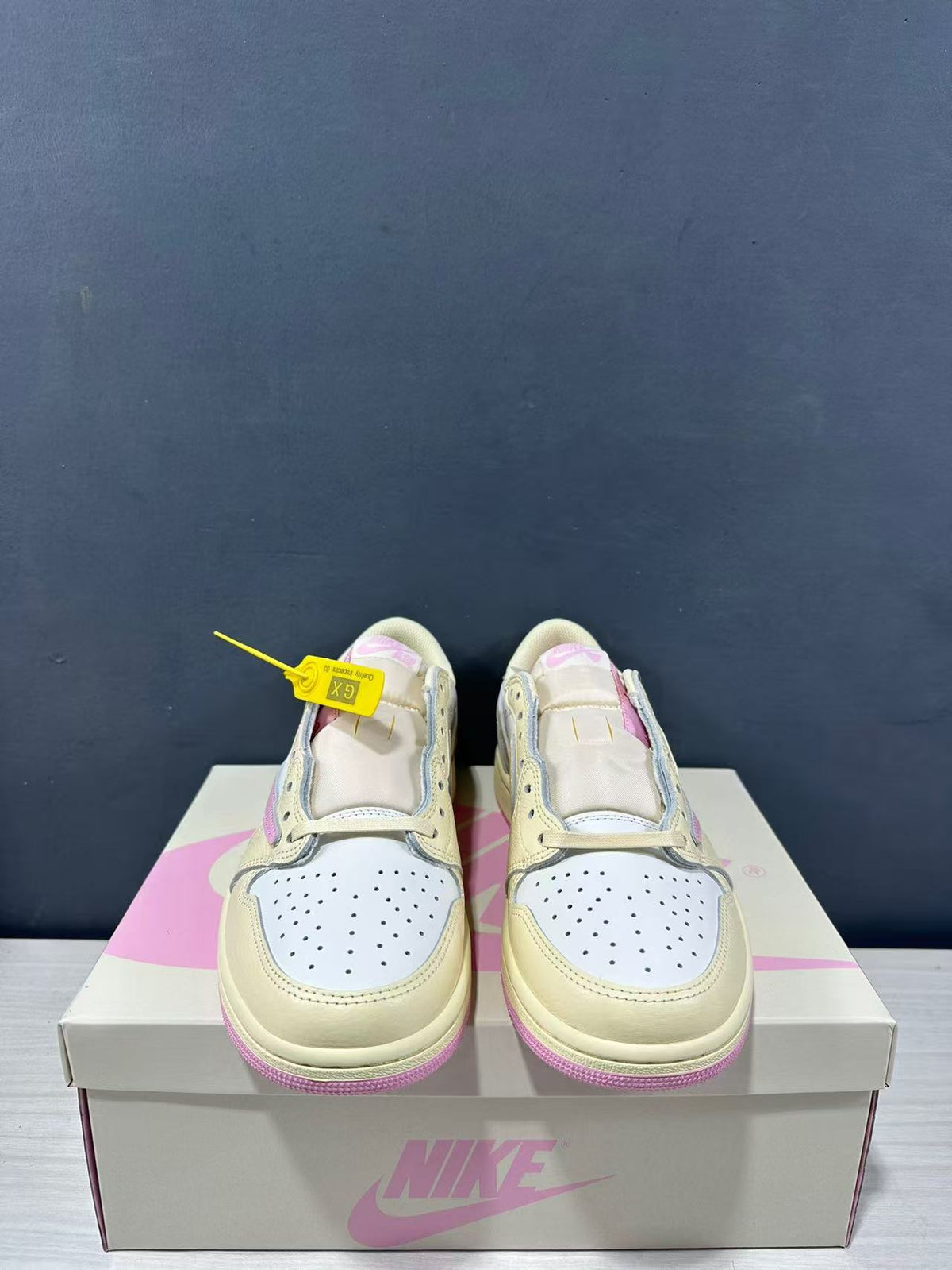 Front view of the pair showing perforated white toe boxes, cream overlays and pink tongue details.