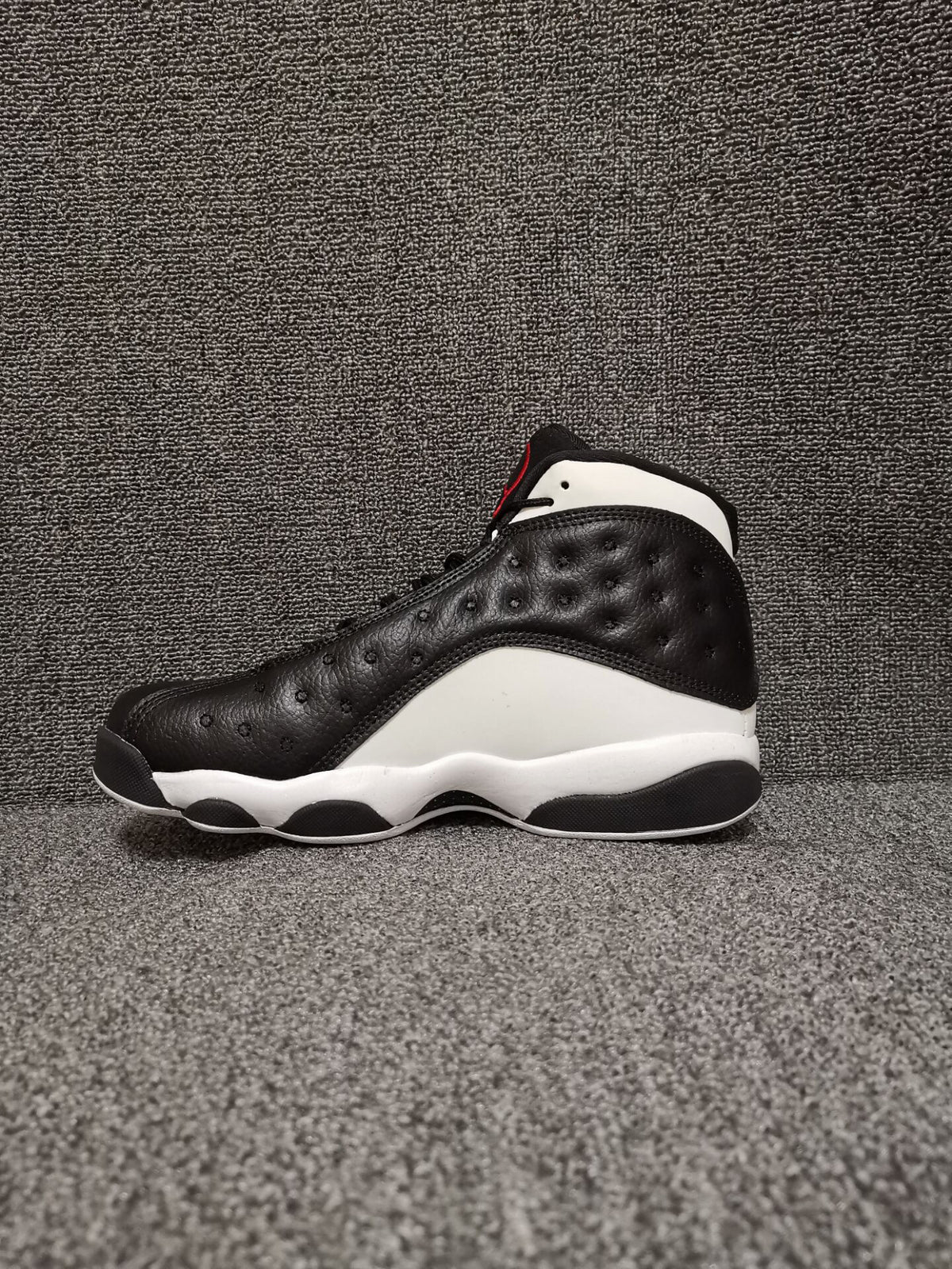 Side profile of a black and white Air Jordan 13 Retro high-top sneaker