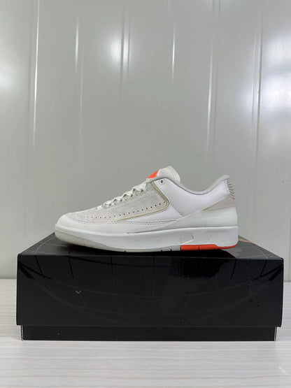 Side profile of the low-top sneaker showing the light beige upper, white midsole, and orange outsole accent.