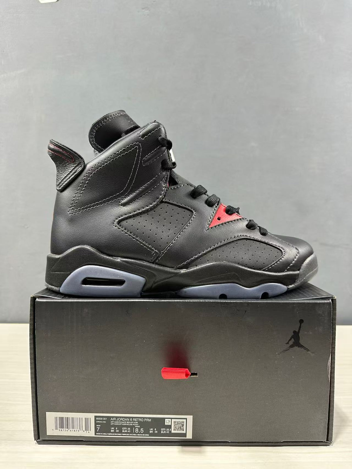 Side view of the sneaker above its box; the box label visibly shows style code II6558-001 and an EU 40 sample size.