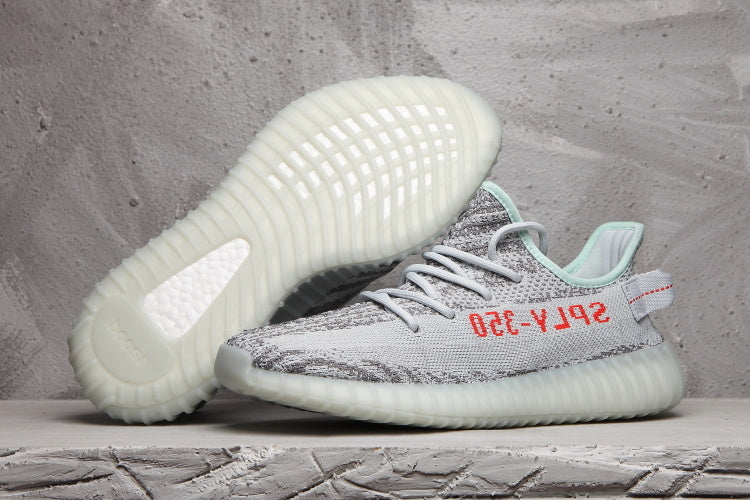 Pair of gray and white Yeezy 350 V2 sneakers showing the patterned upper and translucent ribbed outsoles.